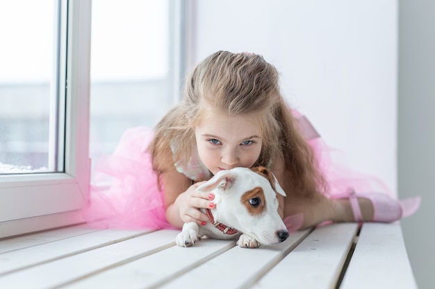 Photo pet and children concept - child with dog jack russell terrier at home.