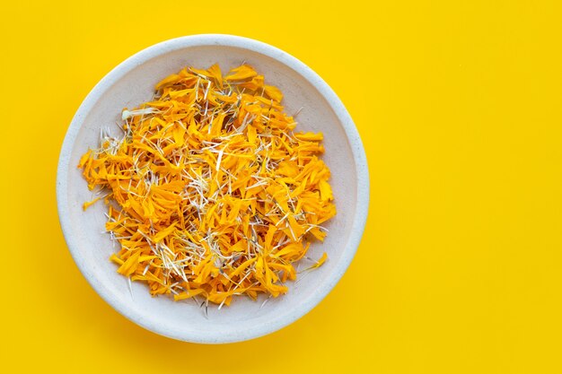 Petals of marigold flower on yellow