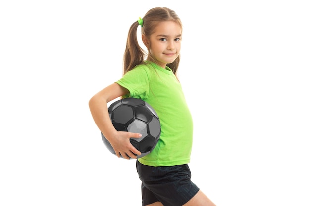 Petite athletic girl with giant holding a ball and smiling isolated on white background