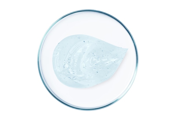 Petri dish with a drop and a smear of a transparent gel or serum on an empty background