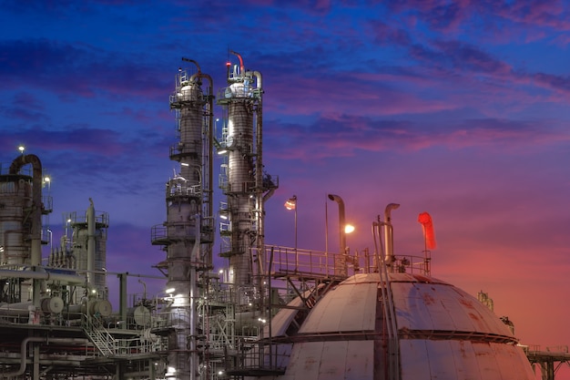 Petrochemical plant on sunset sky background with gas storage sphere tank