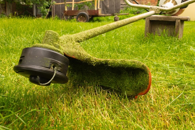 Petrol trimmer mows green grass Photography with movement