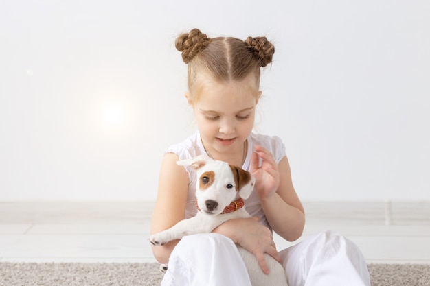 Pets and animal concept  child girl playing with puppy jack russell terrier