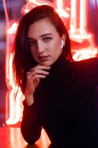 Phantom blue 2020 Trend.Portrait of a girl on the background of a neon sign of a shop window. Retrowave Style with Neon and Pink Lights.