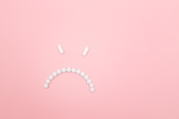 Pharma harm angry smiley face made from white pills