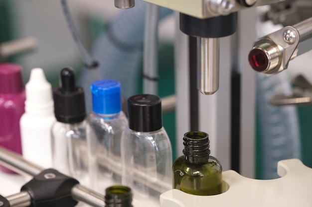 Pharmaceutical industry medicine pills are filling in the bottle on production line machine conveyor at the medical factory selective focus