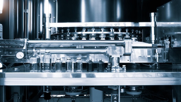 Pharmaceutical industry medicine pills are filling in the bottle on production line machine conveyor at the medical factory selective focus