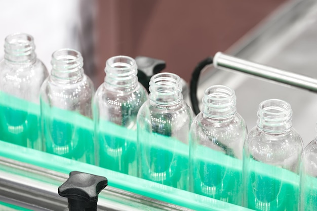 Pharmaceutical industry medicine pills are filling in the plastic bottle on production line machine conveyor at the medical factory selective focus