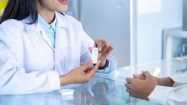 Pharmacist or doctor explaining how to use the pregnancy test sticks to female customers.