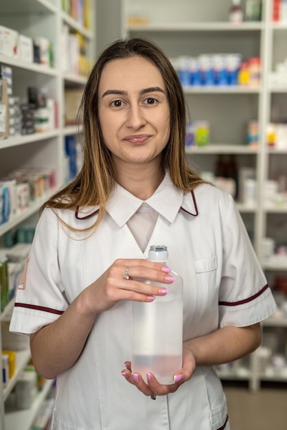 Pharmacist woman holds many medicines in her hands and arranges them on the shelves