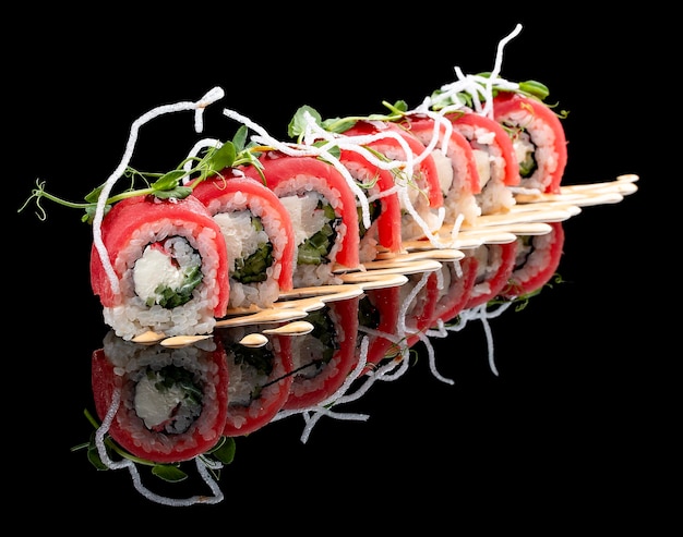 Philadelphia roll with tuna on glossy black background