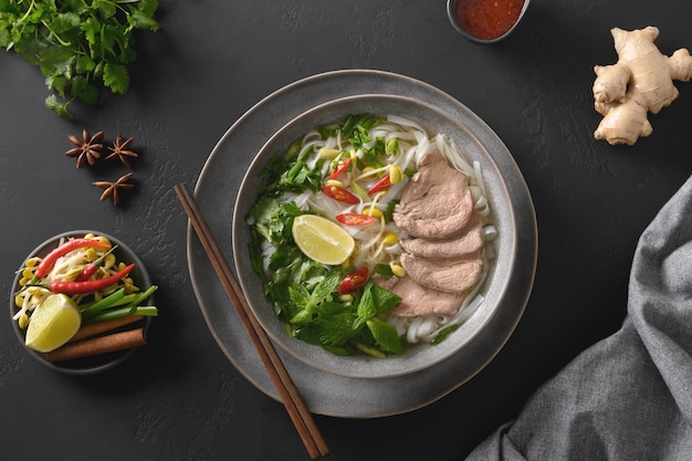 Pho bo soup with beef in bowl on black background vietnamese cuisine