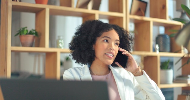 Phone call communication and business woman with a laptop for networking planning and creative work in an office Advertising talking and African employee on a mobile for a strategy for a startup