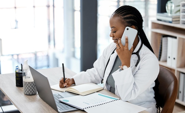 Phone call doctor and black woman writing in notebook for planning medical schedule and agenda Healthcare hospital office and female worker on smartphone for consulting medicare service and help