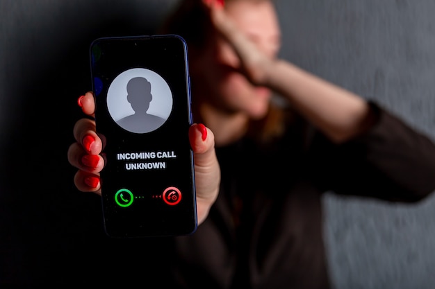 Phone call from unknown number. Scam, fraud or phishing with smartphone concept. Prank caller, scammer or stranger. Woman answering to incoming call. Hoax person with fake identity