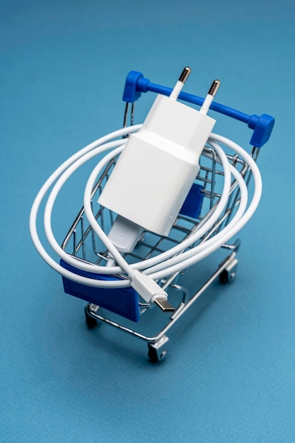 A phone charger in a supermarket cart on a blue background