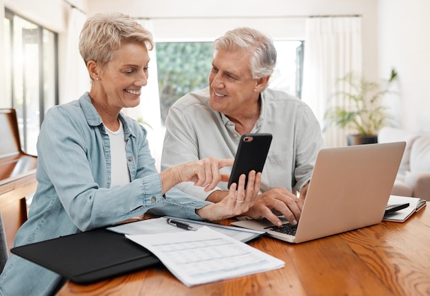 Phone finance and retirement with a senior man and woman working on their will savings and investment together in a home Money communication and documents with an eldery male and female pensioner