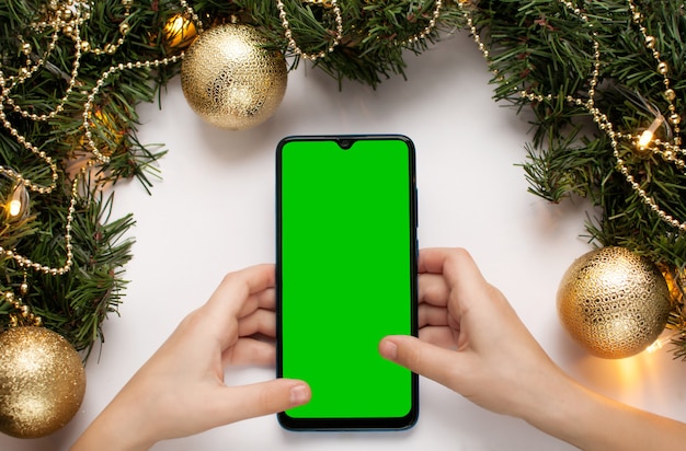 The phone in the hands of a child on a Christmas background