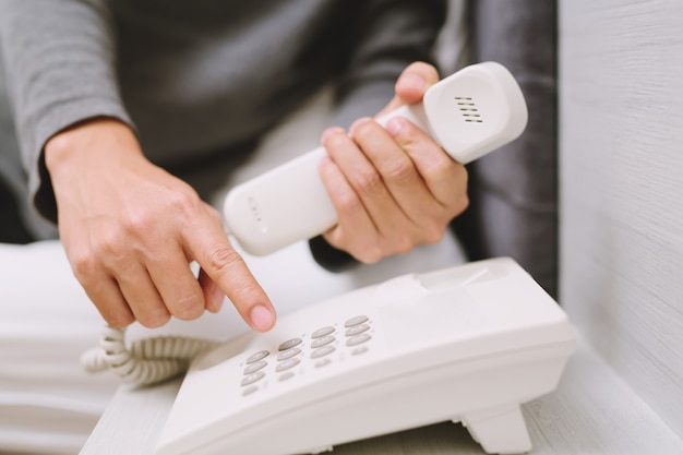 On the phone home: Young man calling talking on the telephone while lying bedroom on home.