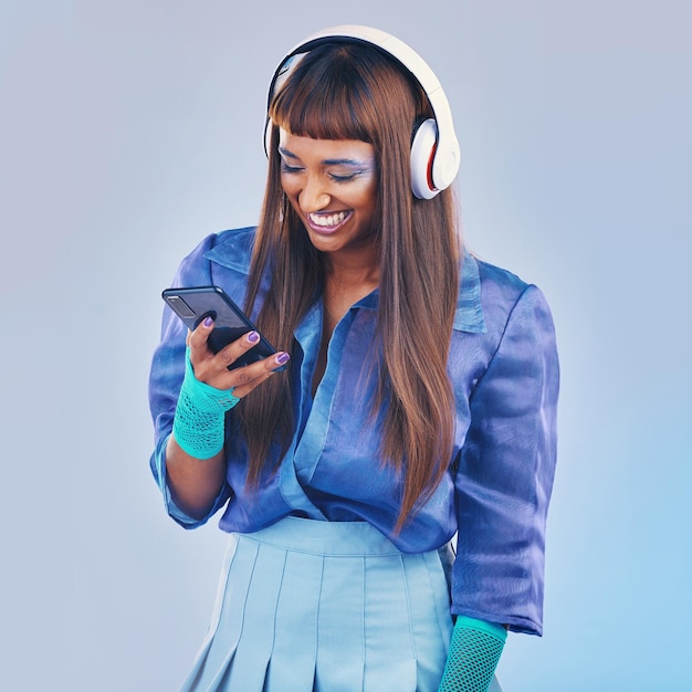 Phone music and fashion with a model black woman in studio on a gray background for contemporary style Social media happy and edgy with a trendy person streaming or listening to audio inside