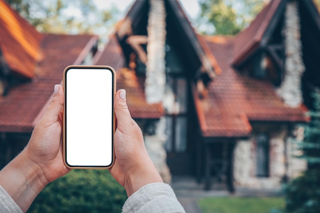 Phone with isolated screen on the background of the cottage