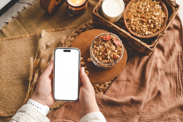 Phone with isolated screen on the background of homemade granola good morning space for your text