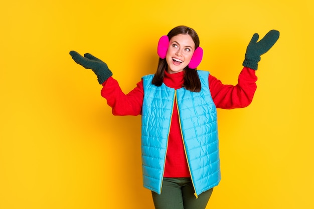 Photo photo of amazed excited girl hold hand catch air fly snowflakes copyspace wear blue pink season clothes isolated over bright shine color background