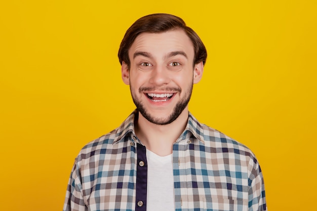 Photo of amazed man in basic clothing screaming in surprise news sale information isolated over yellow background