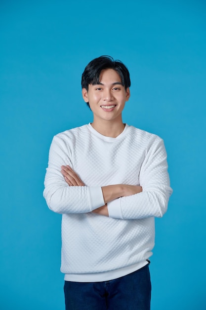 Photo of an Asian businessman standing with his arms crossed and smiling