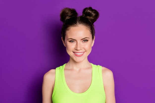 Photo of attractive lady two pretty buns white teeth wide smile wear green singlet isolated violet vivid color background