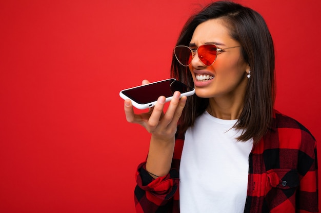 Photo of beautiful angry young brunet woman wearing stylish red shirt white t-shirt and red sunglasses