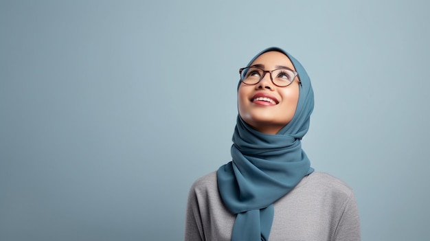 Photo beautiful asian muslim woman in blue sweater and hijab thinking an idea while looking up on wh