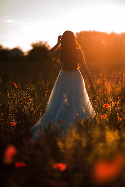 Photo of beautiful happy woman in stylish dress smiling in wheat field