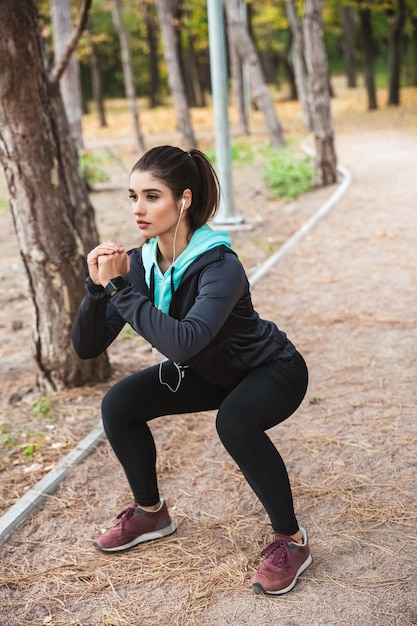 Photo of a beautiful pretty young pretty fitness woman outdoors in the park make sport exercises.