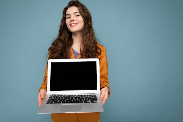 Photo of Beautiful satisfied happy young woman holding computer laptop