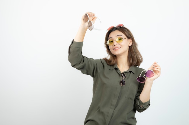 Photo of beautiful woman holding colorful sunglasses over white. High quality photo