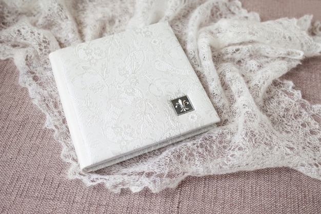 Photo book with a cover of genuine leather. White color with decorative stamping . Soft focus.