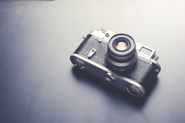 Photo camera on black table background