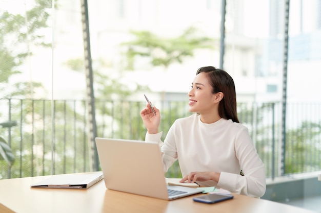 Photo of charming chinese businesswoman sitting at table