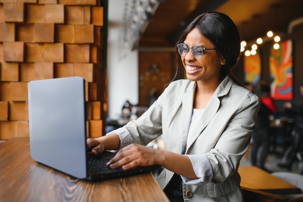 Photo of cheerful ecstatic mixedrace overjoyed entrepreneur executive observing corporate income increased with laptop