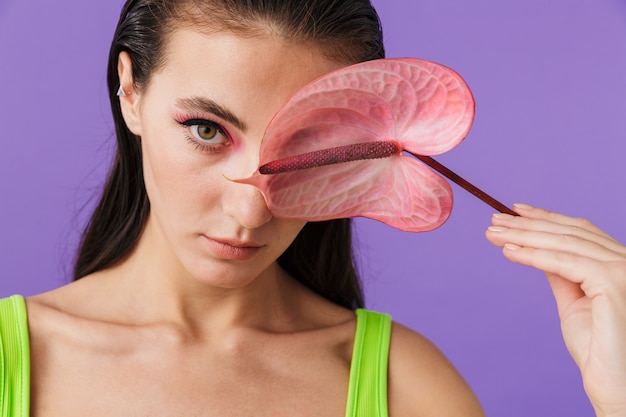 Photo closeup of young fashion woman with bright makeup holding exotic flower