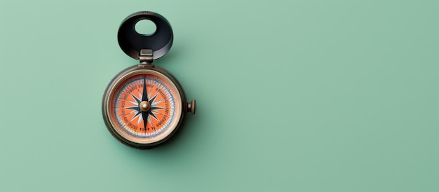 Photo of a compass on a green wall with a black handle with copy space with copy space