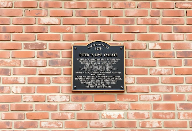 Photo photo depicting old brick wall with a historical plaque