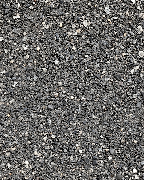 Photo photo of a detailed closeup of asphalt road with granular surface black shiny texture