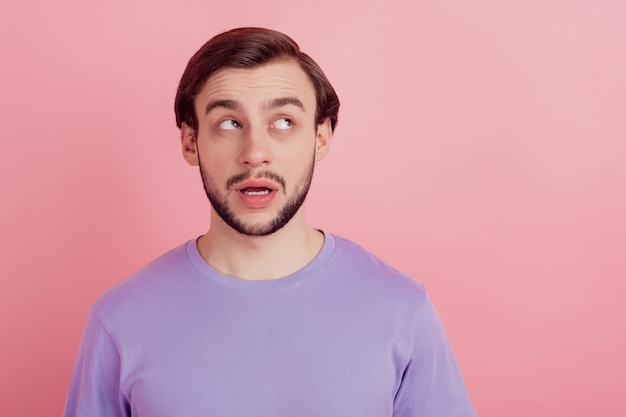 Photo of dreamy minded young man look empty space doubt imagine plan isolated on pastel color background