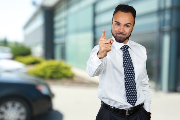 Photo of emotional angry young african man standing isolated