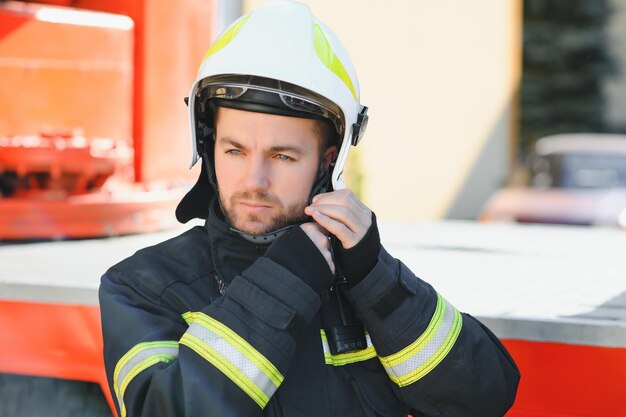 Photo of fireman with gas mask and helmet near fire engine