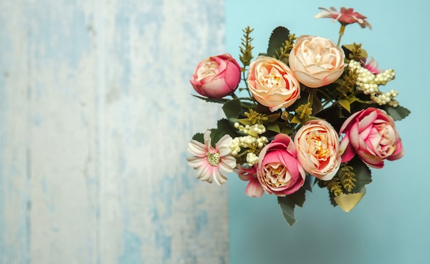 Photo of a flat lay bouquet of flowers roses on a blue textured background with patterns top view