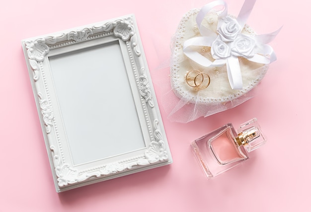 Photo frame and gold rings on white casket bottle of perfume for marriage anniversary