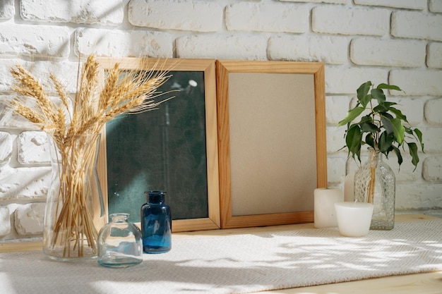 Photo frames on a brick wall background on the table with wheat ears in vase